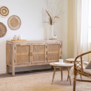Vandana Radiant Grand Julietta Mango Wood and Cane Sideboard is a timeless bohemian storage piece that blends natural materials, warm tones, and everyday practicality. Designed to soften interiors while adding character and functionality, this sideboard reflects the growing trend for organic textures and relaxed, travel-inspired décor. Crafted from solid mango wood and enhanced with handcrafted cane detailing, the Julietta sideboard brings together durability and natural elegance. Mango wood is renowned for its strength, longevity, and warm, sun-kissed hues, making it an ideal choice for furniture meant to last for years. The woven cane door fronts introduce lightness and texture, softening the overall silhouette and creating a relaxed bohemian aesthetic that feels both modern and timeless. The combination of solid wood and caning is a true design classic—two materials that never go out of style. Together, they create a harmonious balance between structure and softness, allowing the sideboard to integrate effortlessly into bohemian, coastal, Scandinavian, contemporary, or eclectic interiors. With its well-proportioned dimensions—148 cm wide, 40 cm deep, and 84 cm high—the Julietta sideboard offers generous storage while maintaining a clean and elegant profile. Behind its three hinged doors, internal shelves provide ample and well-organized space for storing dishes, tableware, books, linens, or clothing, depending on the room in which it is placed. Whether used in a dining room, living area, bedroom, or hallway, this sideboard adapts beautifully to your needs. A thoughtful detail is the magnetic door closure, which ensures smooth and secure everyday use while maintaining a refined finish. The wide top surface offers the perfect opportunity to display decorative objects, plants, lamps, or personal accessories, turning the sideboard into a true focal point within your interior. Delivered fully assembled, the Vandana Radiant Grand Julietta Sideboard reflects quality craftsmanship and attention to detail. By choosing this piece, you are investing in a durable, stylish, and versatile sideboard that brings warmth, texture, and timeless bohemian charm into your home.